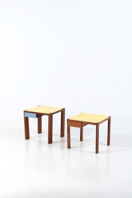 deux petits tabourets en bois placés l'un à côté de l'autre sur une surface blanche