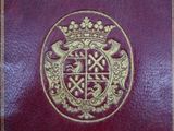 a close up of a red book with a gold emblem on it
