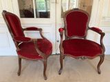 pair of red upholstered chairs in front of a white door