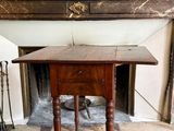 une petite table munie d'un tiroir, placée devant une cheminée