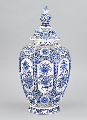 un vase bleu et blanc muni d'un couvercle et orné de fleurs