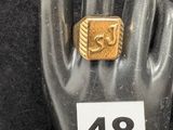 Quelqu'un tient une bague en or posée sur un mannequin portant le numéro 48.