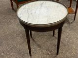 une table avec un plateau en marbre et deux chaises à l'arrière-plan