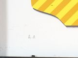 a close up of a yellow and black sign on a white wall