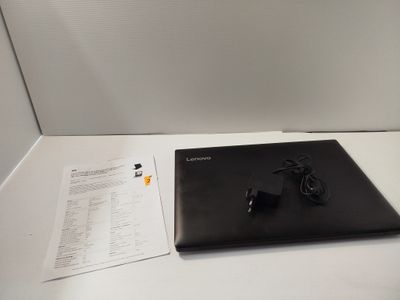 a laptop computer sitting on a table with a charger on it