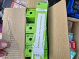 someone is holding a box with a green and white electronic device inside of it