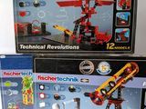trois boîtes de lego technics posées sur une table