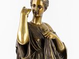 bronze statue of a woman holding a flower in her right hand