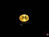 a close up of a yellow diamond on a black surface