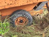 a rusted orange trailer sitting in the grass