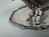 a silver plate with a bird on it on a table