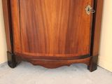 a corner cabinet with a door and a drawer