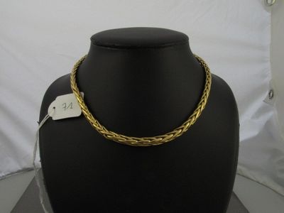 un collier en or sur un mannequin noir, avec une étiquette de prix