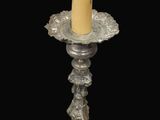 candlestick with a candle on a pedestal with a black background