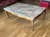 une table basse au plateau en marbre au milieu du salon
