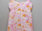 a pink and yellow floral dress hanging on a hanger