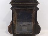 une petite horloge en bois posée sur une surface blanche