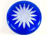 a blue glass object with a white flower on it