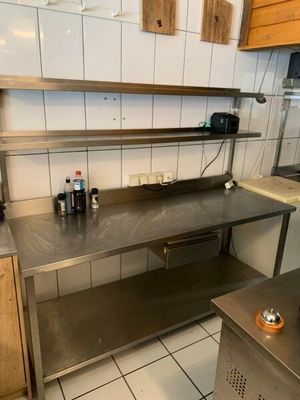 une cuisine avec des plans de travail en inox et un évier
