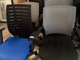 Plusieurs chaises de bureau sont alignées en rang dans une pièce