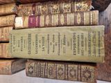several old books are stacked on top of each other on a table