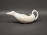une soucoupe en porcelaine blanche en forme de canard, munie d'une anse