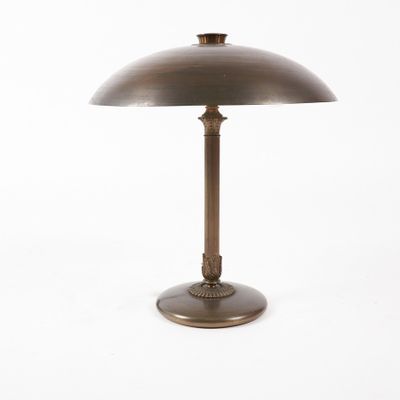 une lampe de table en laiton avec un abat-jour en forme de dôme sur fond blanc