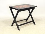 une image représentant une petite table noire ornée d'un motif rouge et noir