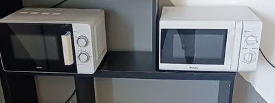 un micro-ondes et un four à micro-ondes posés sur une étagère