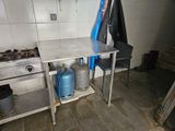 a kitchen with a stove and a table with gas cans on it