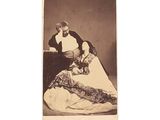 an old photo of a man and a woman sitting on a bed