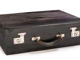 a black suitcase that is sitting on a white surface