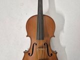 an old violin hanging on a wall next to a white wall