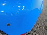 a close up of a blue motorcycle parked in a garage