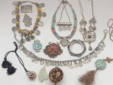 several different necklaces and bracelets are displayed on a white surface