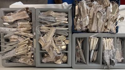 several trays of silverware sitting on top of a table