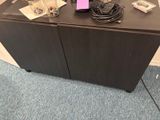 une armoire noire sur laquelle est collé un autocollant rose