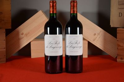 two bottles of wine sitting next to each other on a table