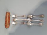 five spoons that are sitting next to a piece of bread