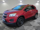 La Chevrolet Trax rouge est garée dans une grande pièce.