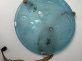 a blue glass plate hanging on the wall next to a rope