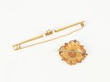 an image of a gold brooch and a pair of scissors on a white surface