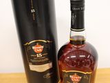 the bottle of whisky is next to the black box on the table