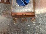 a close up of a metal box with a blue button