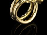une bague en forme de serpent dorée sur fond noir