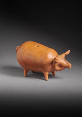a small brown pig figurine sitting on top of a table
