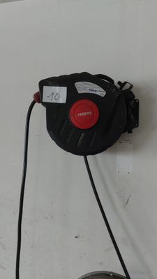 un tuyau noir et rouge fixé à un mur blanc
