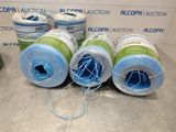 four spools of blue and green thread sitting on top of a table