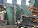 un tas de bois dans un entrepôt, avec une machine en arrière-plan