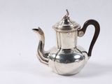 an antique silver tea pot with a wooden handle